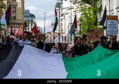 Die Demonstranten skandieren Slogans, während sie während der Demonstration Plakate hinter einer großen palästinensischen Flagge halten. Pro-palästinensische Aktivisten marschierten durch Warschau, um dem 78. Jahrestag der Nakba zu gedenken. Mit Fahnen und Plakaten marschieren Demonstranten von der Botschaft der Vereinigten Staaten von Amerika zur israelischen Botschaft und machen Halt an der örtlichen Bar Plan B, die eine pro-palästinensische Kunstmesse veranstaltete. Die Nakba, arabisch für „Katastrophe“, bezieht sich auf die Massenvertreibung und Enteignung von Hunderttausenden und die Ermordung von Zehntausenden Palästinensern während der arabisch-israelischen Wa 1948 Stockfoto