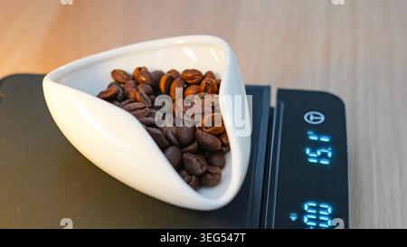 Kaffeebohnen auf digitaler Skala gemessen Stockfoto