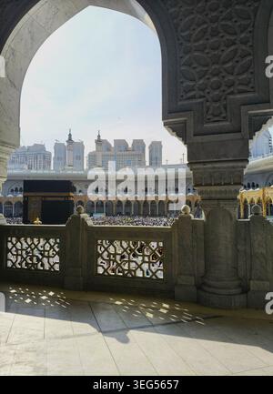 Die heilige Kaaba umrahmt von islamischen Bögen bei warmem Tageslicht Stockfoto