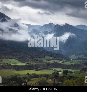 Eine dramatische und stimmungsvolle Landschaft in Vall de Cabó, Katalonien, mit einer riesigen Bergkette im Hintergrund und sanften grünen Hügeln im for Stockfoto