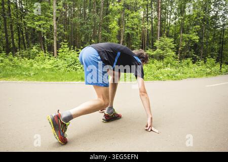 Junger Läufer, der sich auf den Lauf vorbereitet Stockfoto
