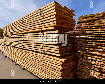 Stapel von Holz Brettern sind ordentlich in einem Außenbau-Lager angeordnet Stockfoto