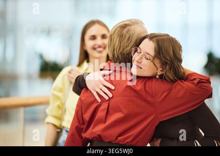 Lächelnde Erwachsene Frauen, die sich in der Mall beim gemeinsamen Einkaufen umarmen Stockfoto