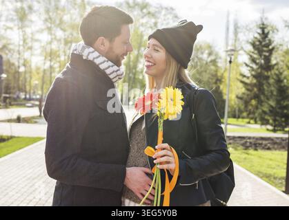 Glücklich schwangere Frau und ihr Mann im park Stockfoto