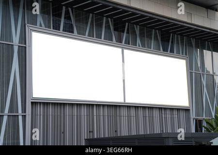 Mockups von zwei leeren weißen Plakatwänden, die von einer modernen Gebäudefassade eingerahmt werden, ideal für Werbung Stockfoto