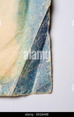Detailansicht einer zerknitterten Papieroberfläche, die die raue Textur und die subtilen Farbvariationen des veralteten Materials zeigt Stockfoto