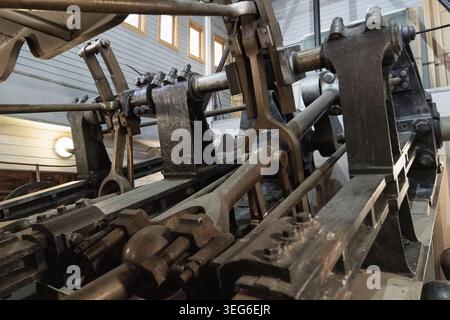 Nahaufnahme des historischen Dampfmaschinenmechanismus im alten Flussdampfboot. Metallstangen, Kolben und mechanische Teile von antiken Marinemaschinen Stockfoto