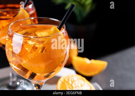 Erfrischende Aperol Spritz-Cocktails mit Orangenscheiben und Eis in eleganten Gläsern Stockfoto