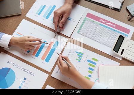 Ostasiatische Geschäftsleute prüfen Buchhaltungs- und Budgetdokumente im Büro. Stockfoto