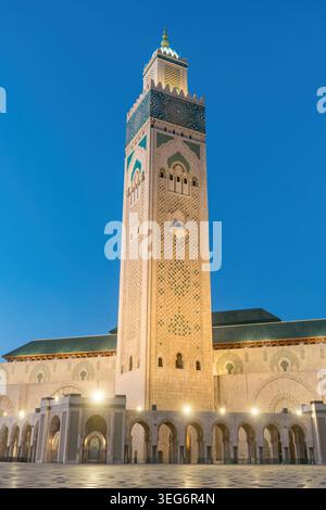 Beleuchtetes Minarett der Hassan II Moschee bei Dämmerung in Casablanca Stockfoto