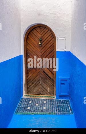 Historische marokkanische Architektur, blaue Wand und traditionelle Holztür Stockfoto