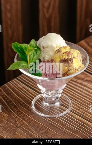 Verschiedene Eiskugeln mit Minzgarnitur in einer Glasschale Stockfoto