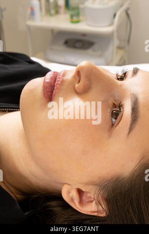 Ein Bild einer sehr schönen und attraktiven jungen Dame, die den Prozess einer Lippenverjüngung zeigt, in einem professionell gestalteten Büro. Dies Stockfoto