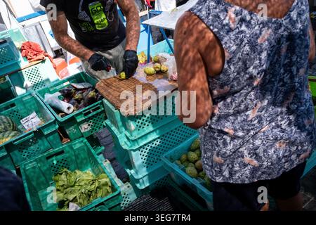 Nahaufnahme eines Gemüseverkäufers, der am 9. August 2025 Kunden auf dem Fischmarkt in Marsaxlokk in der südöstlichen Region Maltas bedient. Das Bild Stockfoto