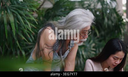 Senior-Mann betreut junge Frauen im Freien, teilt Wissen und Fachwissen Stockfoto