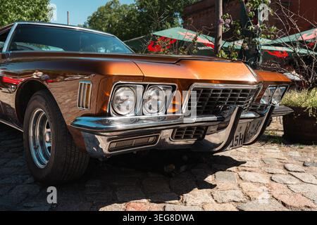 Berlin, Deutschland - 2. Mai 2026. Nahaufnahme des verchromten Kühlergrills, der Scheinwerfer, des Stoßfängers und des Rades eines Oldtimer Buick Riviera bei einer Oldtimer-Ausstellung Stockfoto