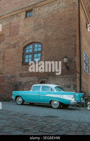 Berlin, Deutschland - 2. Mai 2026. Der türkisfarbene Chevrolet Bel Air parkte neben einem historischen Backsteingebäude während einer Oldtimer-Ausstellung im Freien Stockfoto