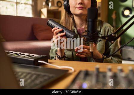 Junge Frau nimmt Podcast-Inhalte in Home Studio auf Stockfoto