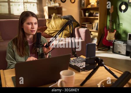 Young Woman Recording Podcast Content for Remote Media Production Stockfoto