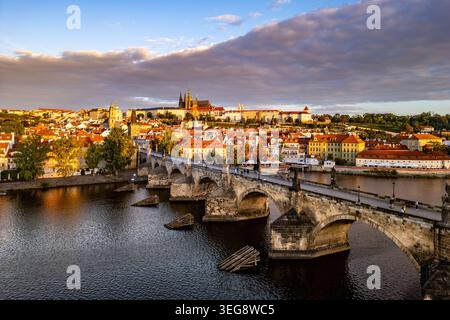 Am frühen Morgen bringt sanftes Licht auf die Prager Burg und die Karlsbrücke. Die ruhige Moldau spiegelt die historische Architektur der Stadt wider und schafft eine ruhige Atmosphäre. Stockfoto