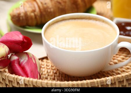 Tablett mit leckerem Frühstück und Tulpenblumen auf dem Tisch, Nahaufnahme Stockfoto