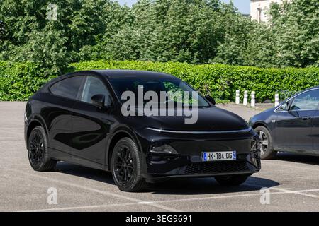Nancy, Frankreich - Blick auf einen schwarzen Xpeng G6 Performance beendet in Midnight Black auf einem Parkplatz mit Vegetation im Hintergrund. Stockfoto