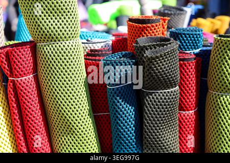 Bunte Rollen aus perforiertem Netzmaterial, die auf dem Markt verkauft werden Stockfoto