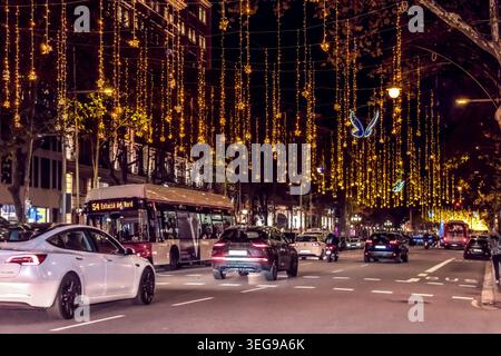 Barcelona, Spanien - 26. November 2021: Nacht Paseo de Gracia Straße mit leuchtenden hängenden Girlanden und blauen Schmetterlingen über einer Straße mit Transport Stockfoto
