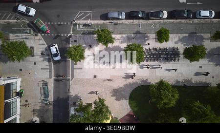 Blick von oben auf die enge Steinstraße mit Bäumen und Schatten in Lissabon, Portugsl Stockfoto