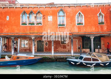 Historisches Gebäude am Kanal mit verwitterter Fassade und Holzläden in Venedig, Italien Stockfoto