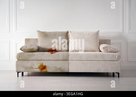 Sofa vor und nach der Reinigung im Zimmer. Collage zum Vergleich Stockfoto