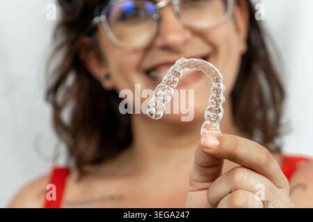 Frau, die einen klaren Zahnauswerter hochhält Stockfoto