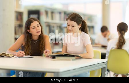Zwei Studentenfreunde studieren gemeinsam in der Universitätsbibliothek Stockfoto