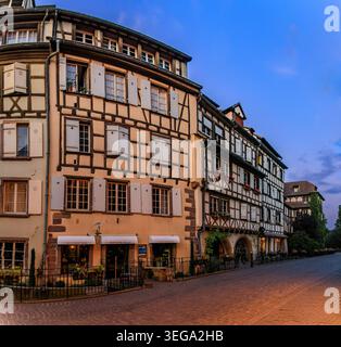 Verzierte traditionelle Fachwerkhäuser mit blühenden Blumen entlang der Kanäle im Viertel Petite Venise in Colmar, Elsass, Frankreich bei Sonnenuntergang Stockfoto
