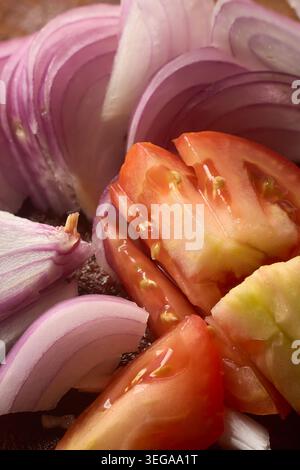 Geschnittene rote Zwiebeln und gehackte Tomaten in Makroansicht aus der Nähe, Vollbild-Textur in weichem Fokus, gesundes Kochen Stockfoto