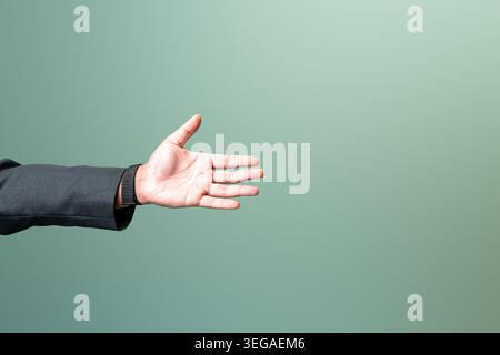 Nahaufnahme einer professionellen Hand in einem Anzug, die sich für einen Händedruck oder eine Hilfsleistung öffnet, vor einem sauberen grünen Hintergrund mit freiem Platz. Stockfoto