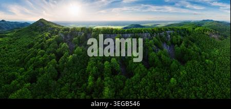 Farbenfroher Sonnenuntergang in den Bergen der Kleinen Karpaten in der Slowakei mit frischem grünem Gras und Blättern auf den Bäumen im Tal, Frühlingsabend Stockfoto