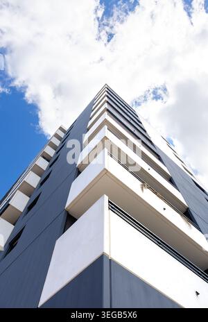 Zeitgenössische städtische Architektur mit geometrischen Betonbalkonen und dunkelblauer Fassade eines Hochhauses an einem hellen Tag. Cle Stockfoto