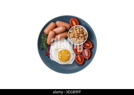Essen, gebratene Hühnereier, Würstchen, Kirschtomaten, Kichererbsen, Gewürze, Salz und Kräuter. Leckeres, nahrhaftes Frühstück Stockfoto
