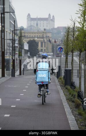 Bratislava, Slowakei - 15. April 2025 : Wolt Fahrradkurier bei der Arbeit in Bratislava. Essenslieferservice Stockfoto