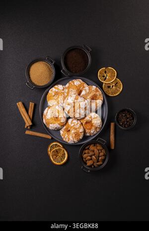 Orange Crinkle Plätzchen mit Backzutaten auf einem schwarzen Tisch Stockfoto