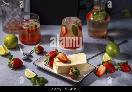 Mojito-Cocktails mit ErdbeerLimetten und Käsekuchen zum Nachtisch Stockfoto
