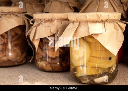 Hausgemachtes eingelegtes Gemüse und marinierte Pilze in Glasbehältern Stockfoto