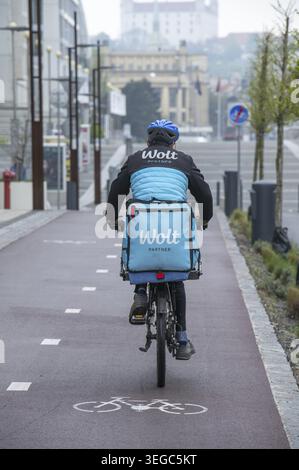 Bratislava, Slowakei - 15. April 2025 : Wolt Fahrradkurier bei der Arbeit in Bratislava. Essenslieferservice Stockfoto