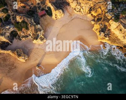 Aus der Vogelperspektive auf Wellen, die über Sand und türkisfarbenes Wasser am Strand Praia de Sao Rafael brechen. Stockfoto