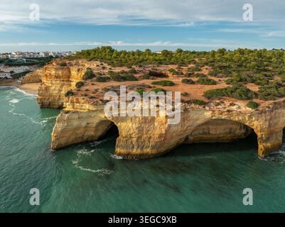 Blick auf die Klippen über der Benagil-Höhle in der Algarve, Portugal, mit Kalksteinhöhlen, türkisfarbenem Atlantikwasser, Wellen und zerklüfteter Küste. Stockfoto