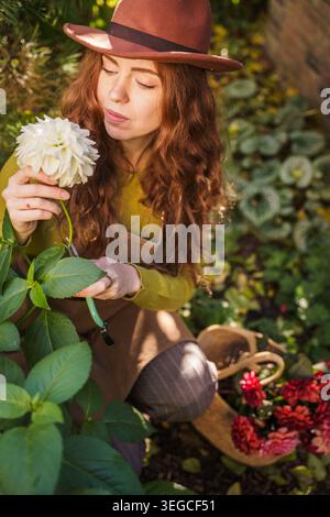 Rothaarige Frau Hält Dahlia Bouquet Im Nordic Garden Stockfoto