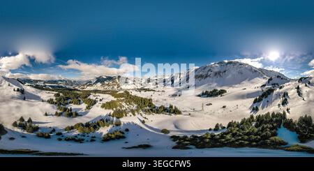 Aus der Vogelperspektive auf die schneebedeckten Berge und Kiefernwälder der UNESCO Biosphare Entlebuch unter einer hellen Sonne in Soerenberg, Luzern, Schweiz. Stockfoto