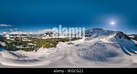 Luftaufnahme der UNESCO Biosphare Entlebuch mit schneebedeckten Berggipfeln, immergrünen Wäldern und Skipisten unter klarem blauen Himmel in Soerenberg, Stockfoto
