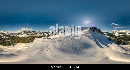 Luftaufnahme der UNESCO Biosphare Entlebuch mit schneebedeckten Berghängen, dichten Kiefernwäldern und einem klaren blauen Himmel in Soerenberg, Luzern, S Stockfoto